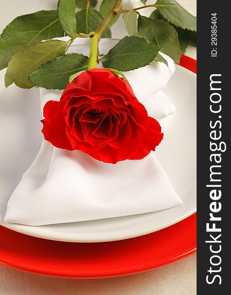 Romantic dinner setting with a rose and white napkin
