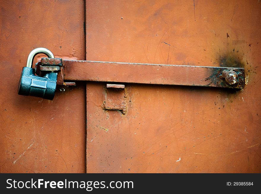 Old metal door closed on the lock. Old metal door closed on the lock