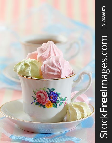 Colorful meringue cookies in vintage chic tea cup