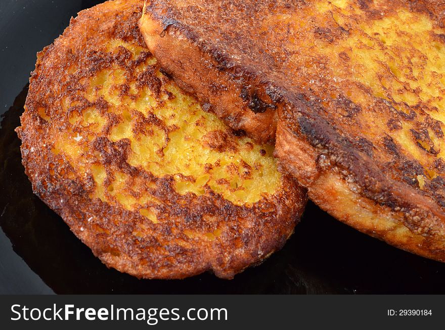 Macro shot of toasted bread and eggs in black plate