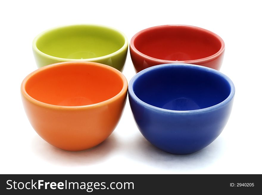 A red, green, orange and blue bowl isolated on white. A red, green, orange and blue bowl isolated on white.