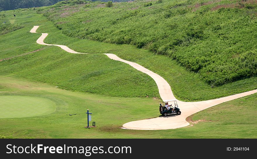 Two golfers in a cart on a cart path fading into the past. Two golfers in a cart on a cart path fading into the past