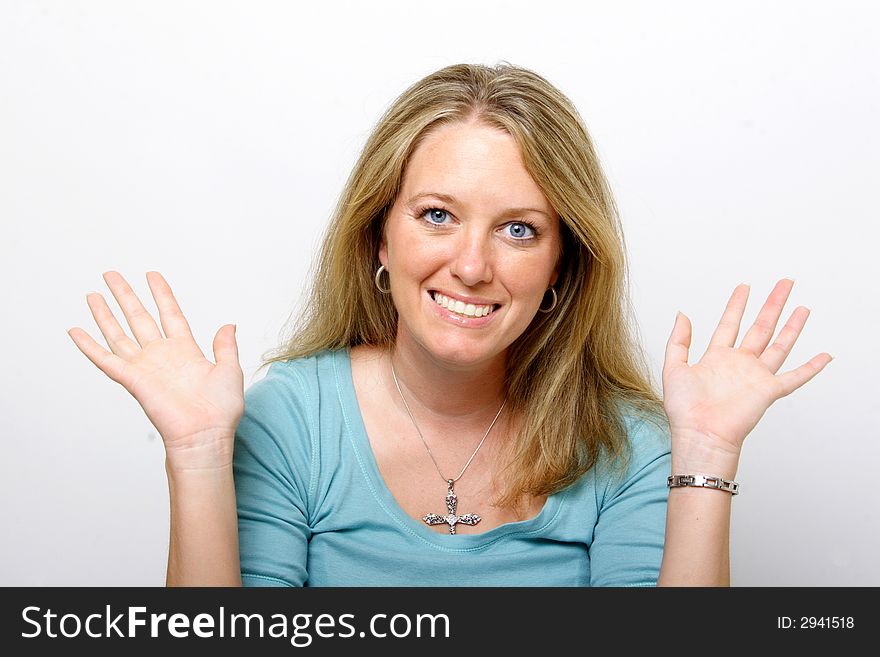 A young lady with her hands up smiles into the camera. A young lady with her hands up smiles into the camera.