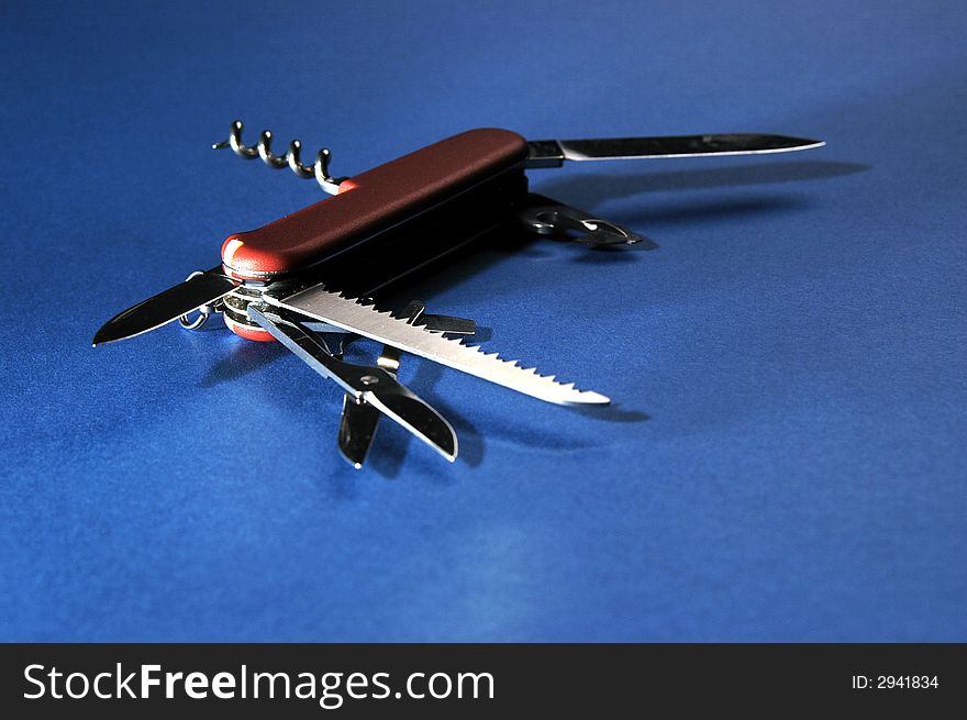Photo of red penknife on blue background