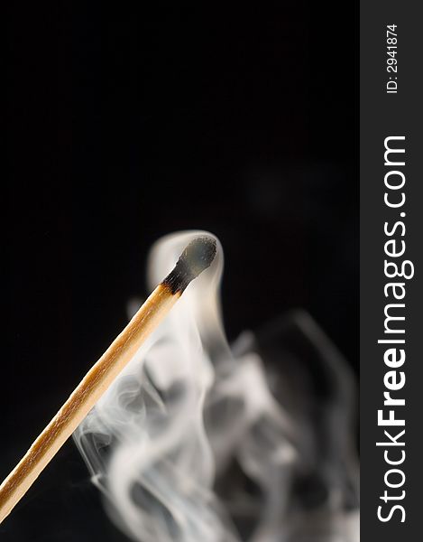 Close up of a smoking match on a black background