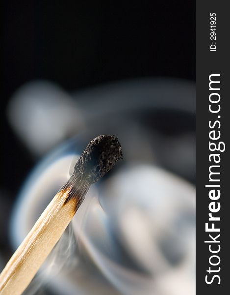 Close up of a smoking match on a black background