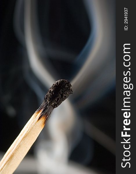 Close up of a smoking match on a black background