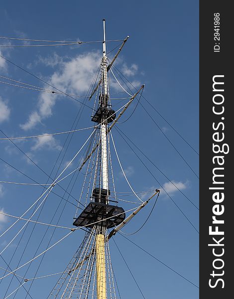 Mast of ship on blue sky and clouds background