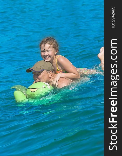 The grandfather swimming together with the granddaughter. The grandfather swimming together with the granddaughter