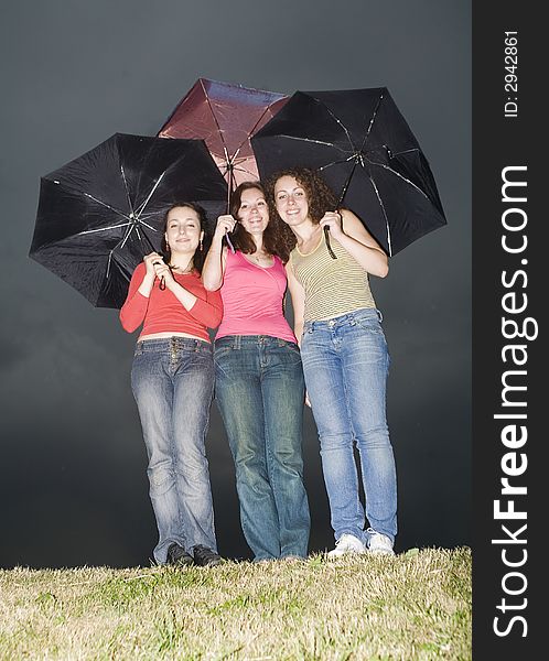 Three girls with colored umbrellas. Three girls with colored umbrellas