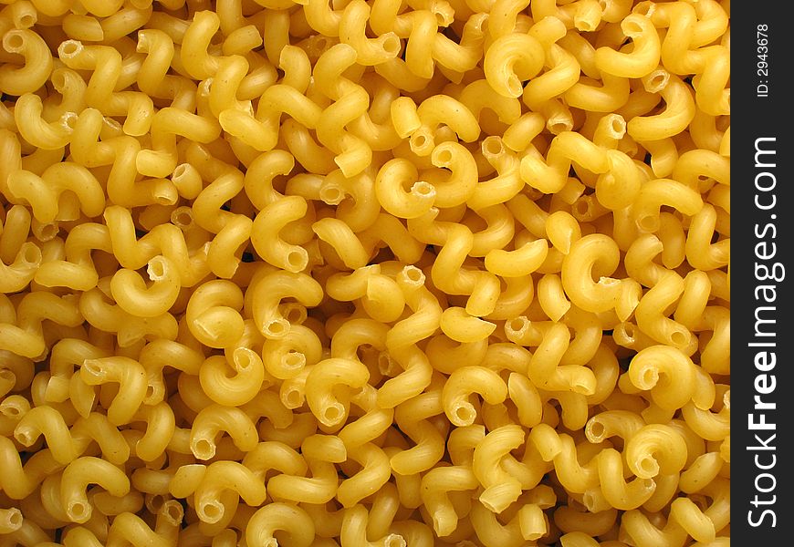 Backgrounds. Heap of raw golden macaroni-spiral