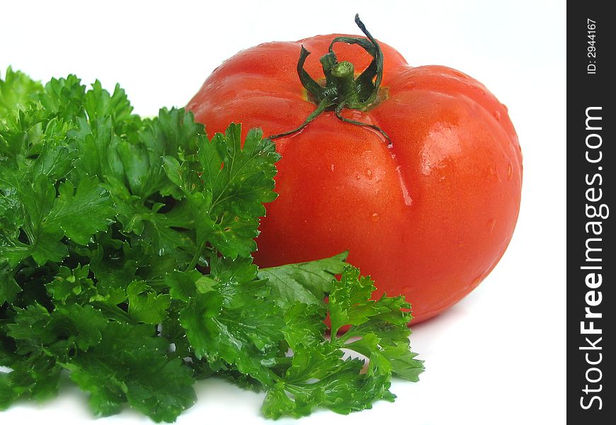 Tomatoes and greens on white background, close up