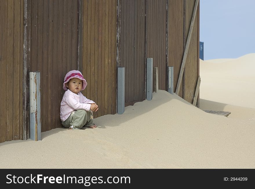 Sweet little girl leaning against a beachhouse. Sweet little girl leaning against a beachhouse