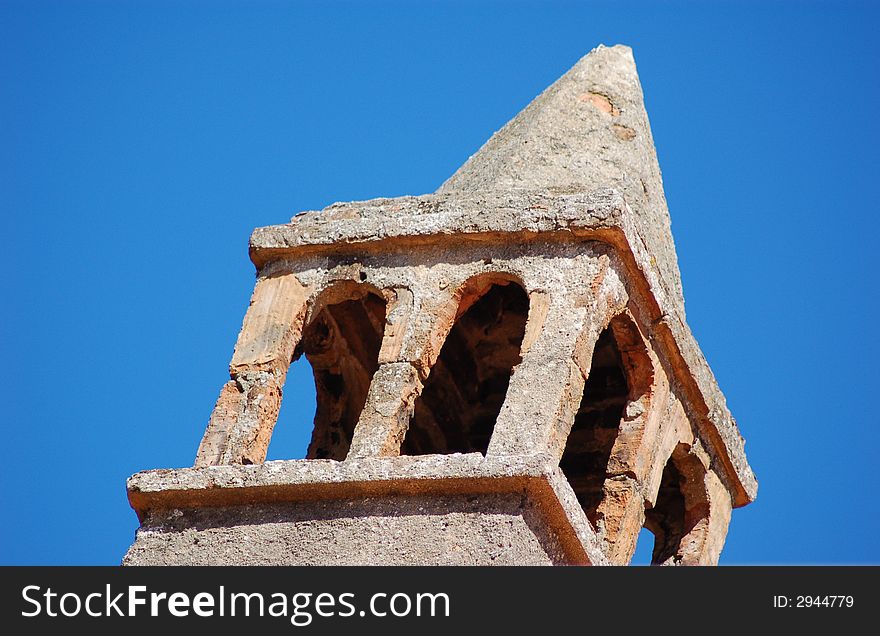 Traditional dalmatian stone chimney against blue sky.