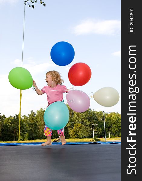 Girl with balloon runs on lawn