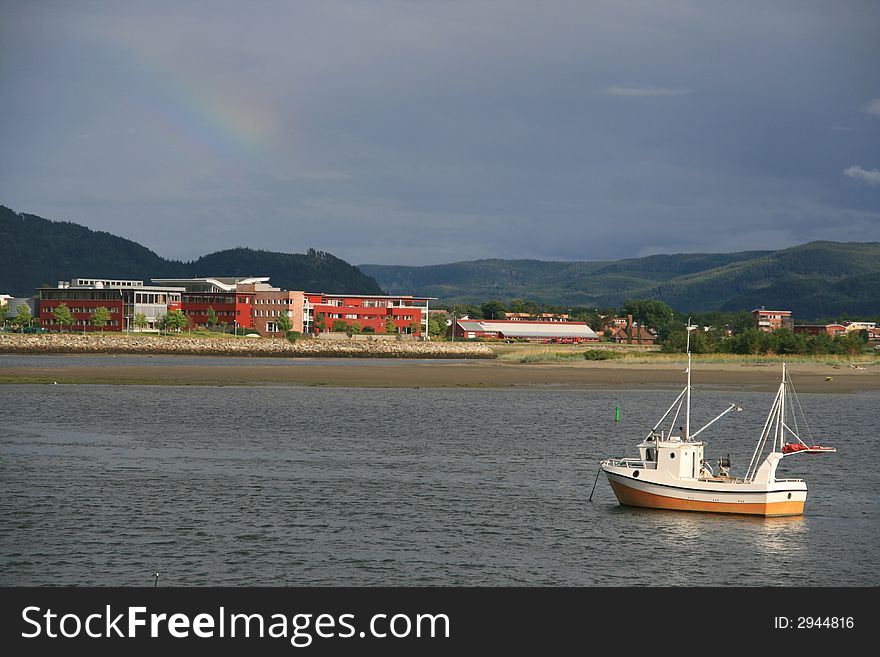 Small fishing boat near a harbor with buildings