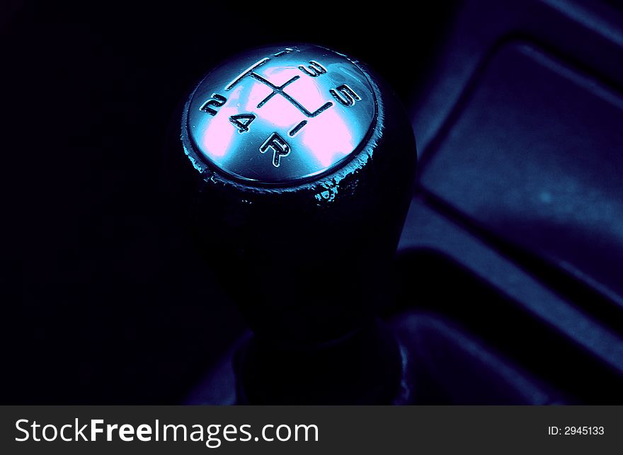 Taken in a sport type car looking down at gear five speed. Taken in a sport type car looking down at gear five speed