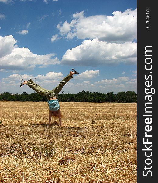 Young woman in yellow field do handsprings. Young woman in yellow field do handsprings