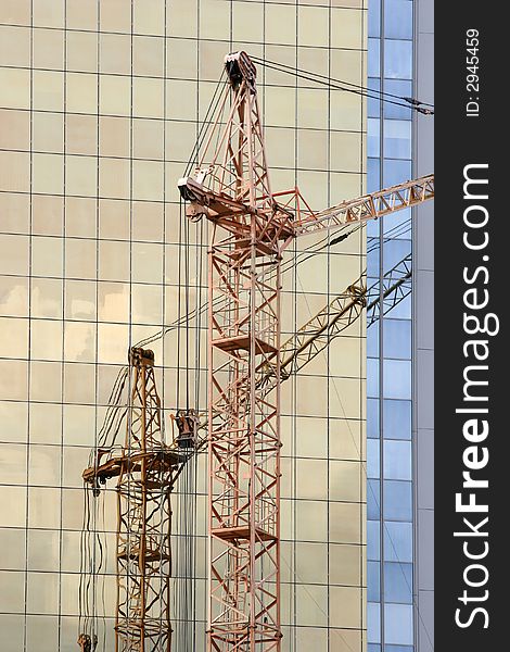 Construction crane in front of golden skyscraper