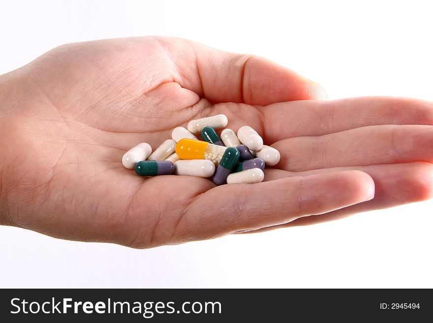 A hand holds a variety of colorful pills. A hand holds a variety of colorful pills.