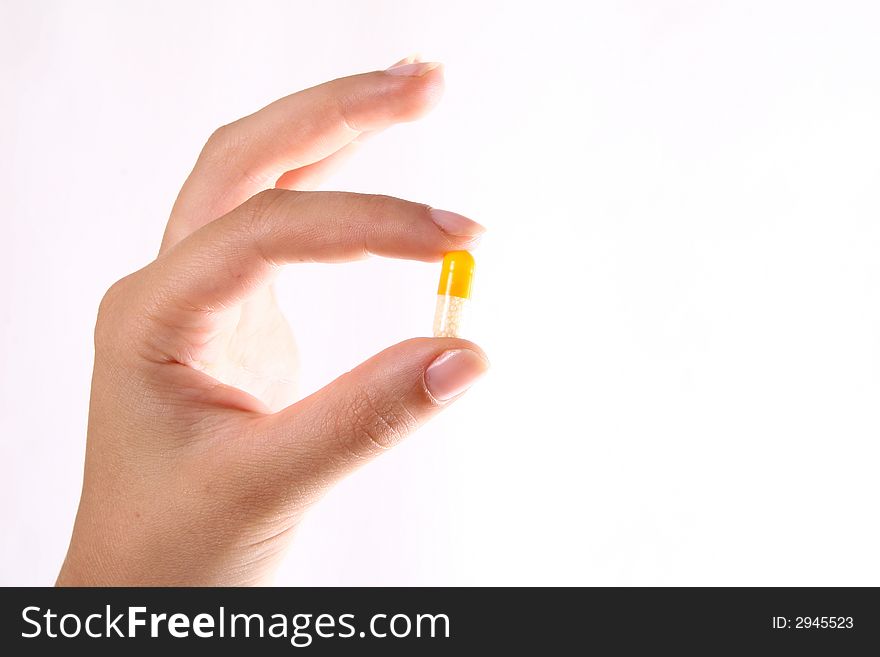 A hand holding a pill over white background!. A hand holding a pill over white background!