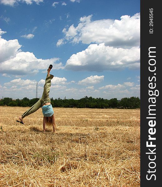 Young woman in yellow field do handsprings. Young woman in yellow field do handsprings