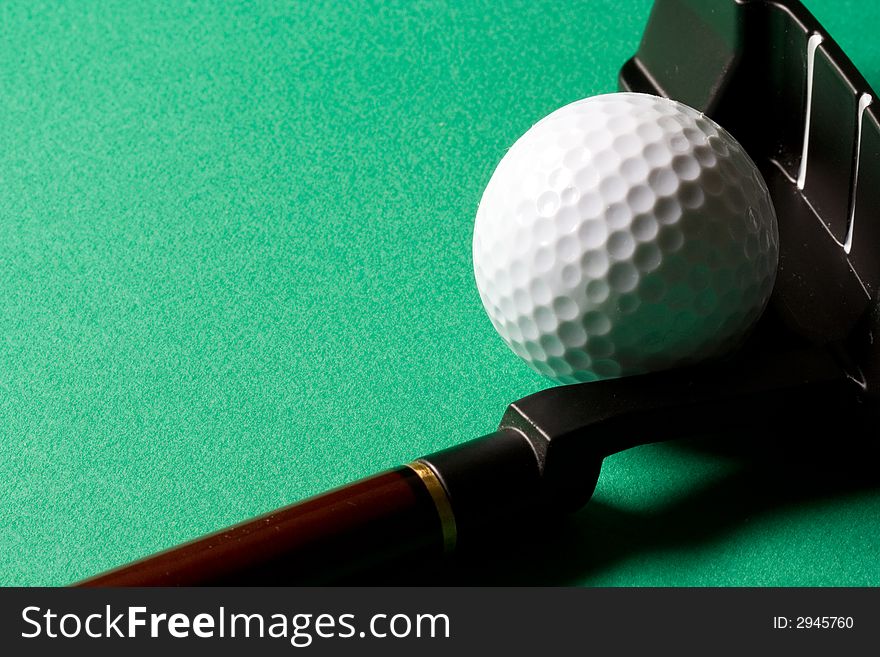 Golf club and ball on green background