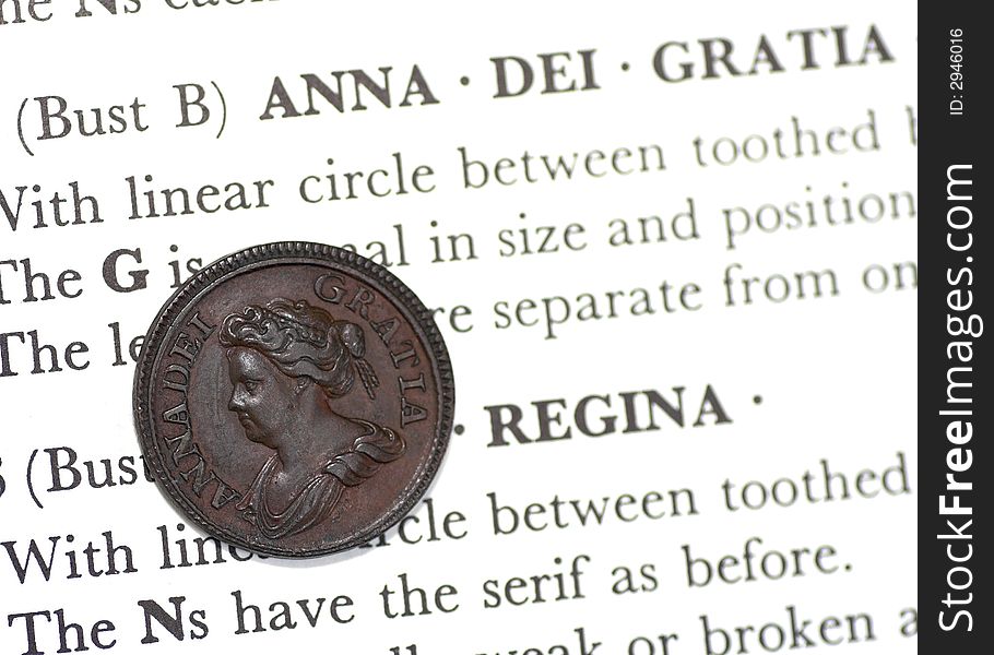 Rare copper Queen Anne farthing on the page of a coin book.