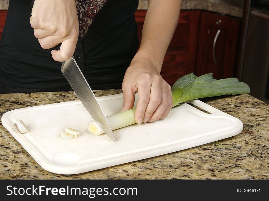 Cook slicing end of leak - preparing a meal. Cook slicing end of leak - preparing a meal.