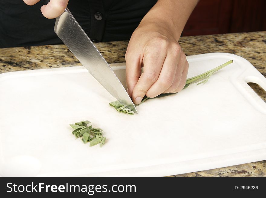 Preparing food, cutting the herb sage using a knife. Preparing food, cutting the herb sage using a knife.