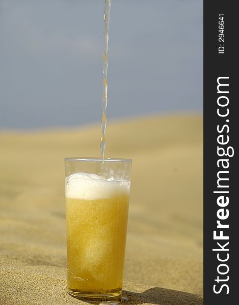 A glass of fresh beer in a desert. A glass of fresh beer in a desert.