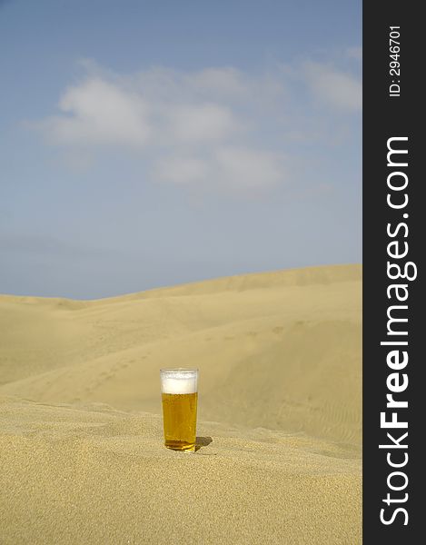 A glass of fresh beer in a desert. A glass of fresh beer in a desert.