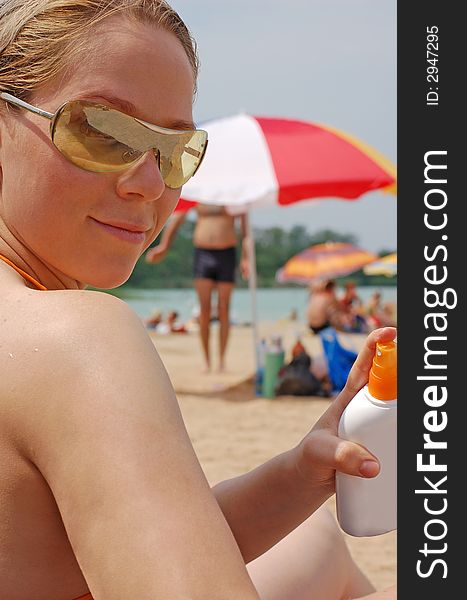 A woman holding a sunscreen. A woman holding a sunscreen