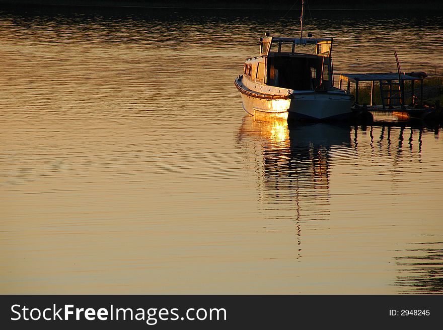 Old boat on the river at sunset