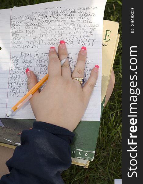 Hand on written homework paper with mechanical pencil