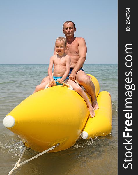 Grandfather with the grandson they sit on the inflatable boat