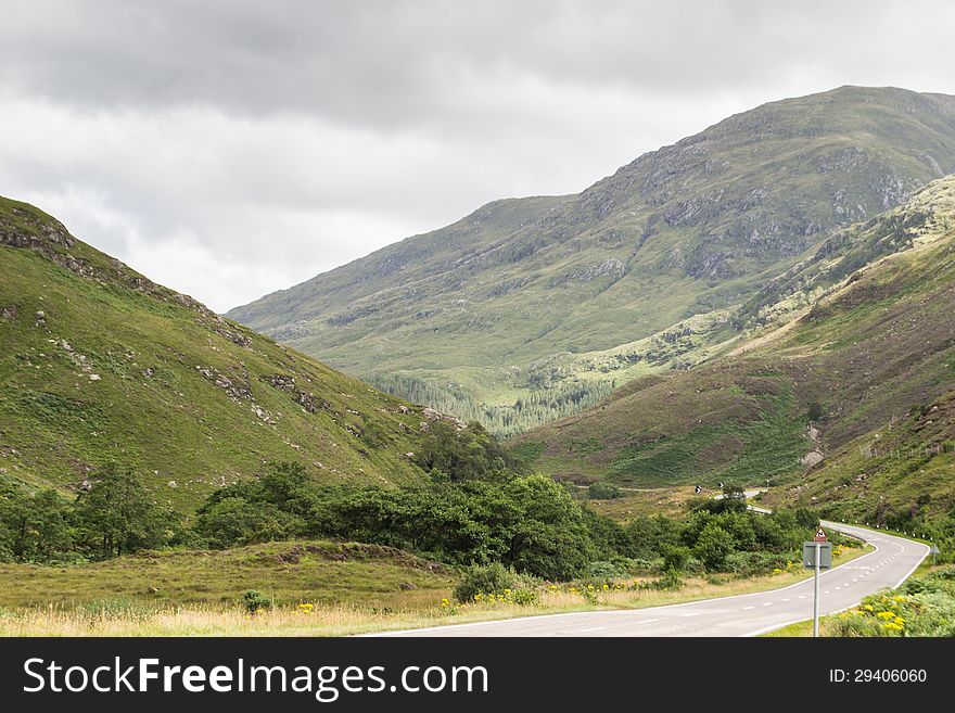 Road in the middle of scottish highland during a sunny summer day. Road in the middle of scottish highland during a sunny summer day