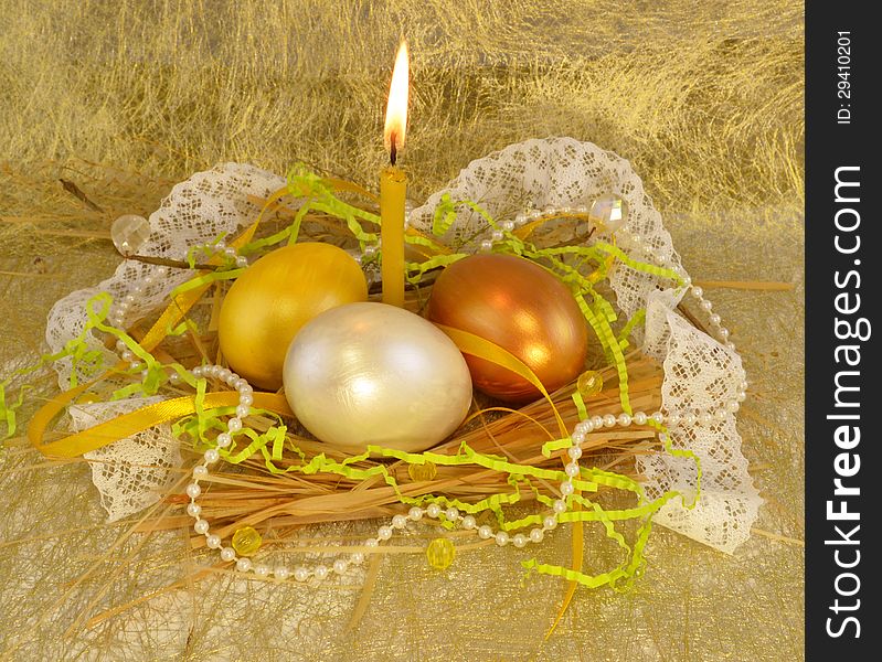 Three gold easter eggs with candle and beads