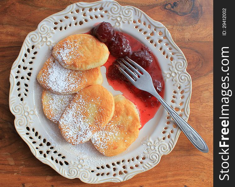 Pancakes with strawberry jam on table