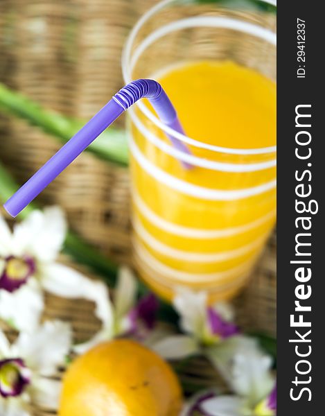 Close up violet drinking straw in glass of orange juice. Close up violet drinking straw in glass of orange juice