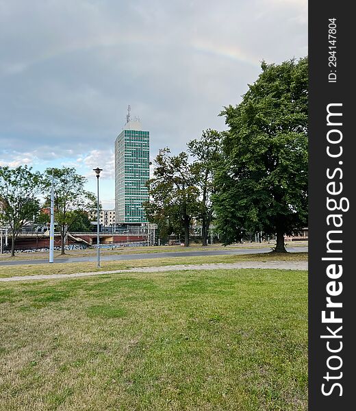 Gdansk, Poland - 08.08.2022: Rainbow over an old multi-story office building with green glass.