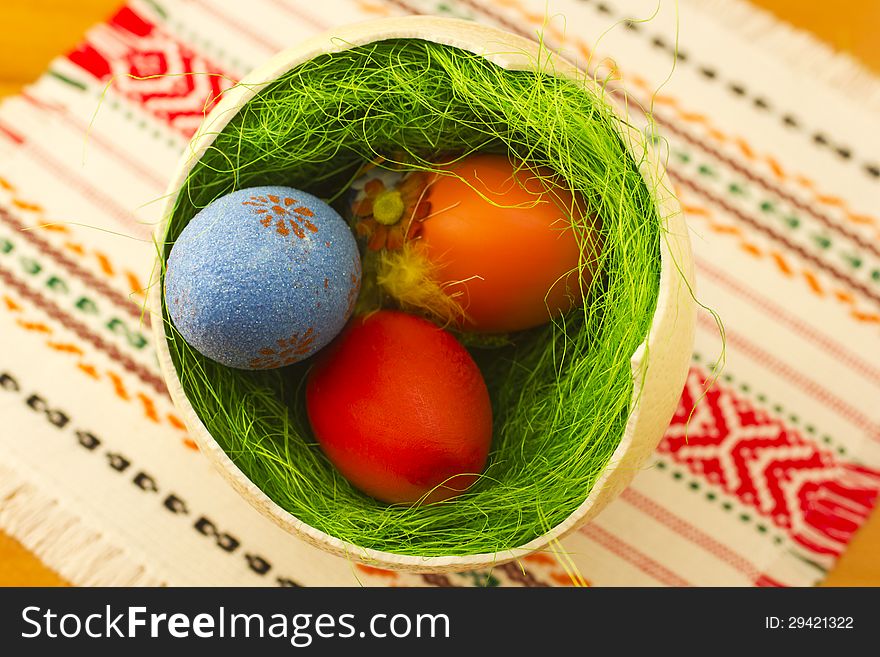 Colored Easter eggs in one big ostrich egg with grass.