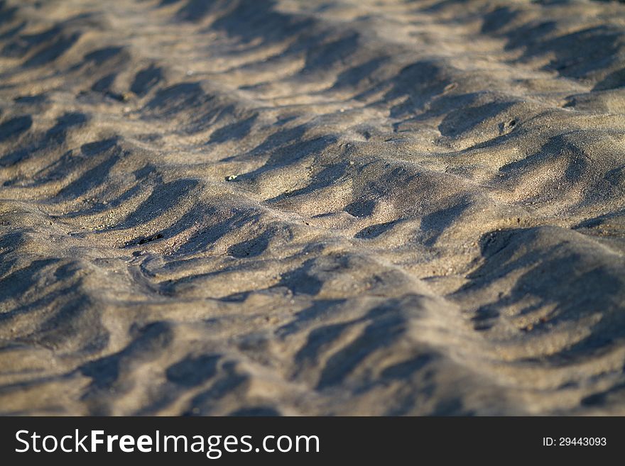 Texture of the gray beach sand  during the morning sidelight