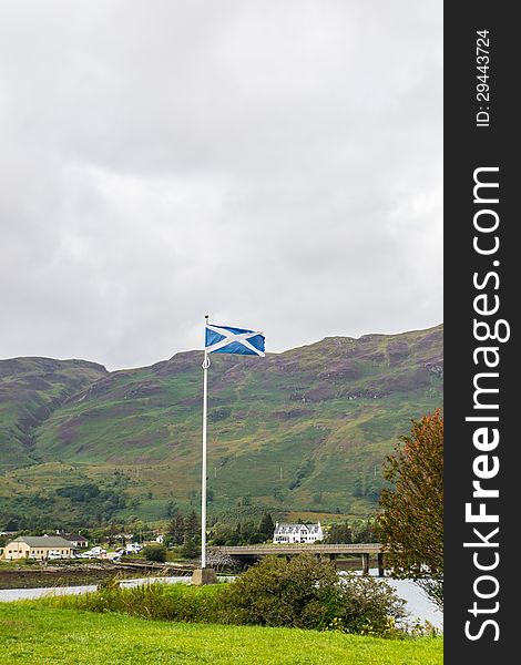 The Saltire flag above near Eilean Donan Castle, Dornie Village, Skye Island Scotland. The Saltire flag above near Eilean Donan Castle, Dornie Village, Skye Island Scotland