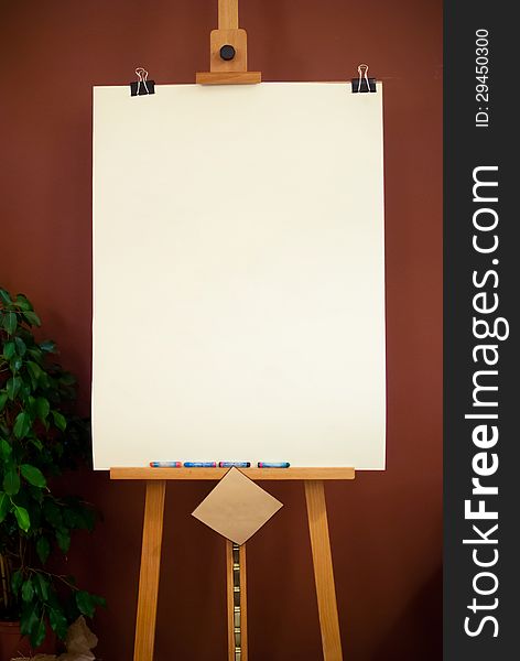 Wooden Art Easel with white paper on Brown Background. Wooden Art Easel with white paper on Brown Background