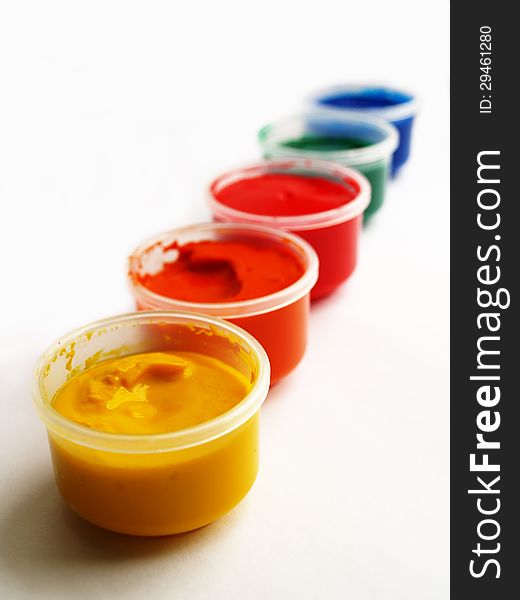 Open plastic containers of paint in primary colors. Open plastic containers of paint in primary colors