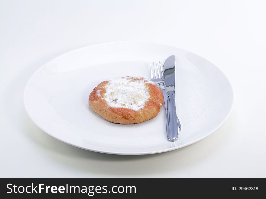 Cheese cake on a white plate, knife and fork