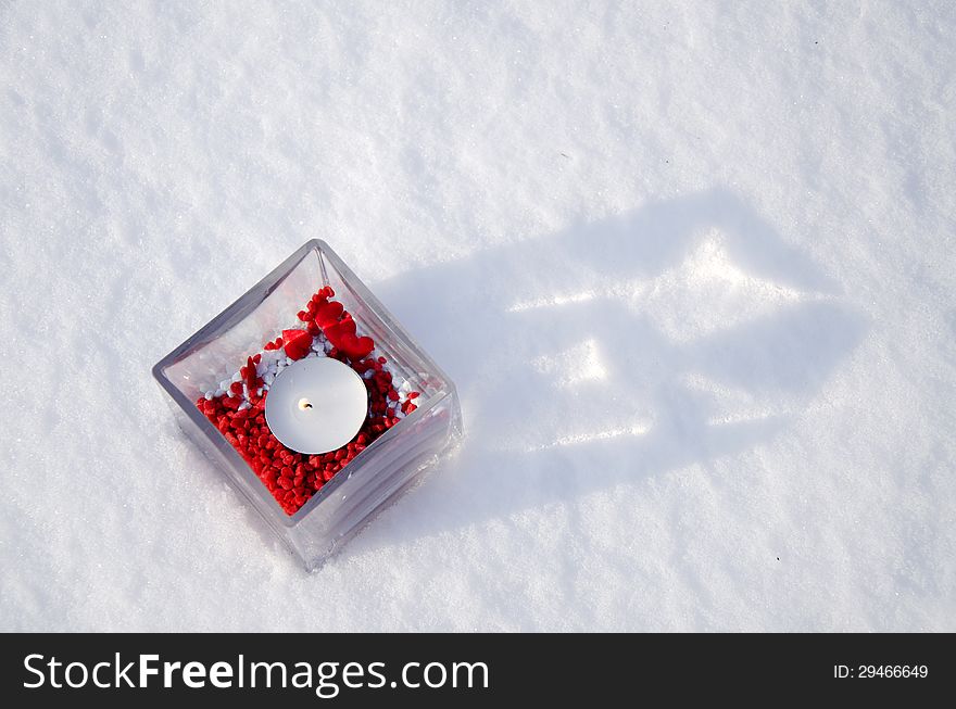 Candle with red decoration in winter