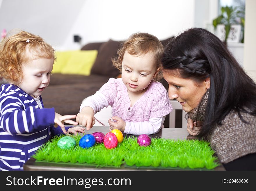 Mom and her children playing with easter eggs.