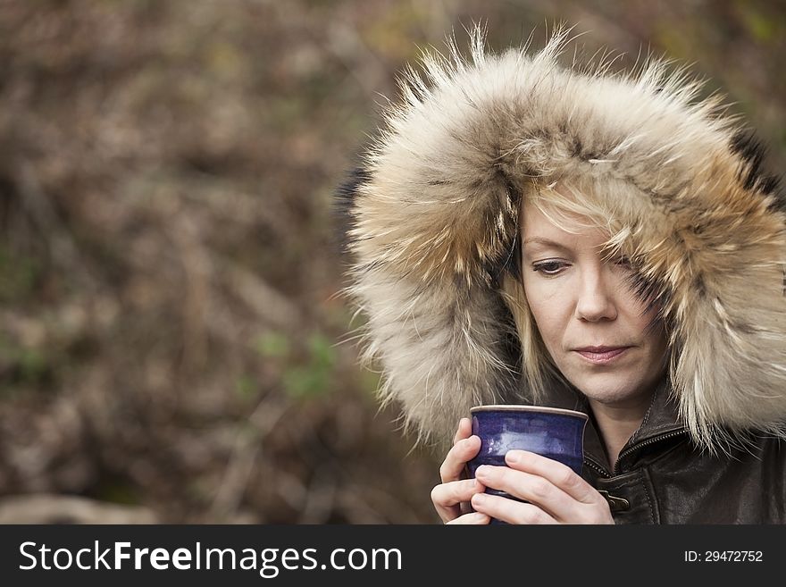 Portrait of a blonde woman in attractive winter coat drinking coffee. Portrait of a blonde woman in attractive winter coat drinking coffee.